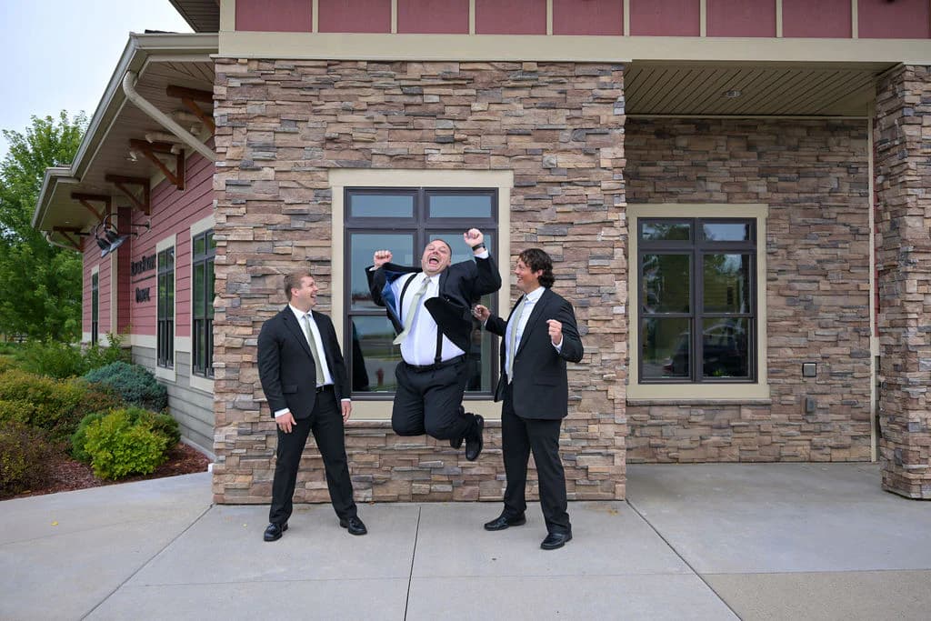 Dr. Christopher Carroll celebrating with Dr. Bryce Carroll and Dr. Joshua Carroll outside River Street Dental